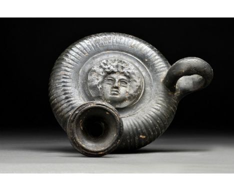 Circa 360-320 BCA ceramic black-glazed guttos with discoid body, pedestal foot, loop handle and trumpet-shaped spout; circumf