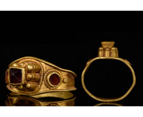 Circa 600 ADA gold ring with a large tapering band, leading onto a bulbous shaped bezel. The bezel houses a trumpet which lea