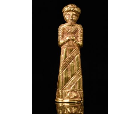 Circa 700-500 BCA hollow cast statuette of a priest formed of sheet gold with an elaborately decorated long robe decorated wi