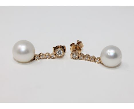 A pair of 14ct yellow gold white pearl and diamond earrings, featuring two white pearls, two brilliant cut diamonds 0.15ct an