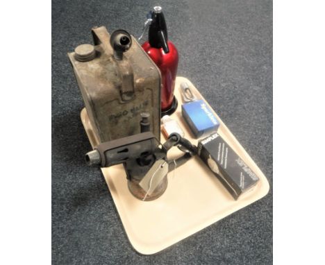 A tray of vintage soda siphon with accessories, brass blow torch and an Esso blue paraffin tin 