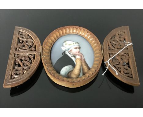 A portrait miniature of a pretty girl painted on porcelain with wooden picture frame fretwork and closing protective doors.
