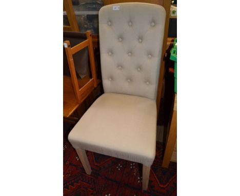 A cream upholstered button backed bedroom chair