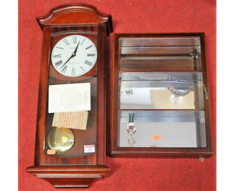 A modern mahogany effect President quartz Westminster chime wall clock; together with a mahogany effect wall mounted display 