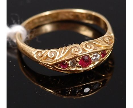 An 18ct gold, ruby and diamond ring, arranged as three graduated round cut rubies dispersed with a single small old cut diamo