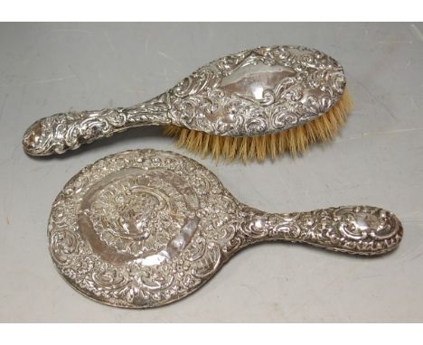 A silver and embossed hand mirror with matching hairbrush (2)