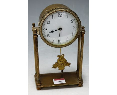 An early 20th century brass cased drum shaped mantel clock, having enamelled dial with Arabic numerals, arranged on four reed