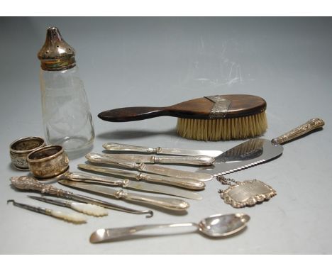 A collection of miscellaneous items to include silver topped glass bodied sifter, silver napkin rings, silver decanter label 