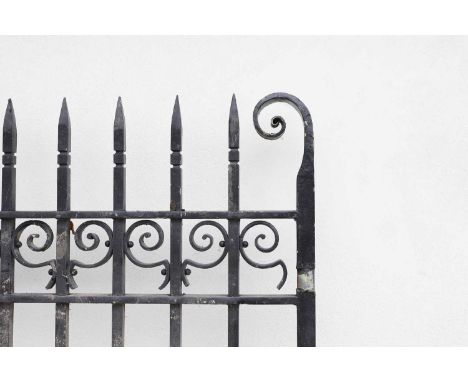 Two pairs of cast iron gates, early 20th century, with scrolling detail, each pair set between a pair of white-painted cast i