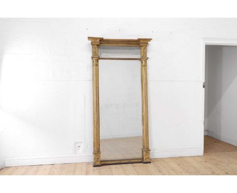 A Regency-style carved giltwood pier glass, 19th century, the frame with neoclassical decoration and column pilasters flankin