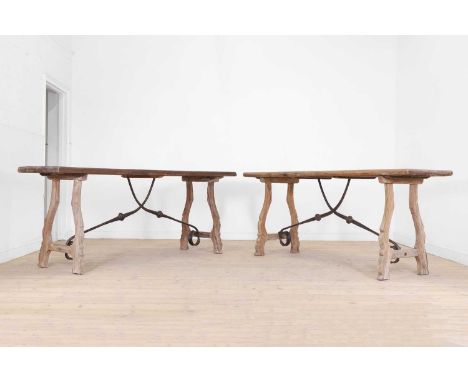 A pair of oak and iron console tables, 20th century, Continental, each plank top raised on 'os de mouton' supports united by 