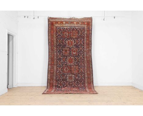 A Kazak wool rug, 20th century, Caucasian, the indigo fields with repeating geometric motifs within a triple border, 330 x 15