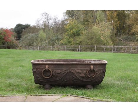 A Tang-style cast iron trough, 20th century, Chinese, the sides cast with foliate designs, with loop handles,114cm wide 60.5c