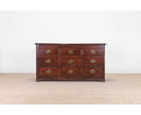 An oak dresser base, 18th century, the rectangular top above nine beaded drawers, raised on squat ogee bracket feet, 152cm wi