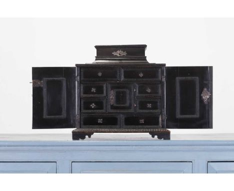 An ebonised pearwood table cabinet, early 18th century, Dutch, with all-over ripple moulding, the pagoda top with a hinged li
