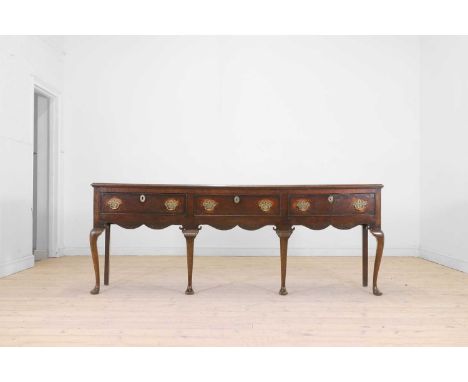 A George II oak dresser, second quarter of the 18th century, the moulded rectangular top above three frieze drawers on cabrio