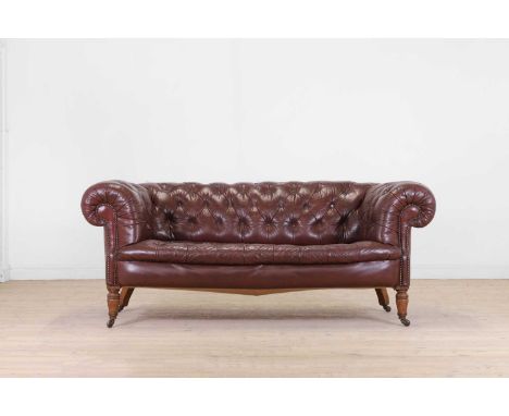 A Victorian buttoned leather chesterfield sofa, c.1890, raised on ring-turned oak supports, terminating in caps and castors, 