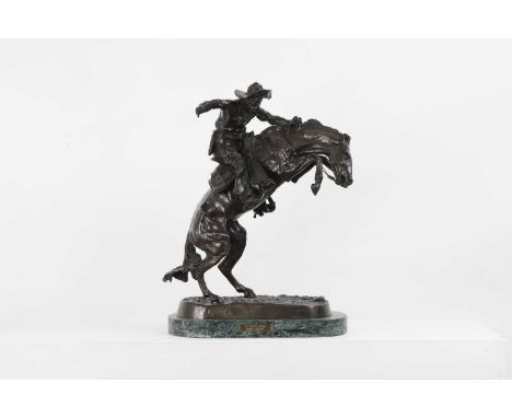 After Frederic Remington, 'The Bronco Buster', bronze, mounted on an oval green marble plinth, impressed signature and titled