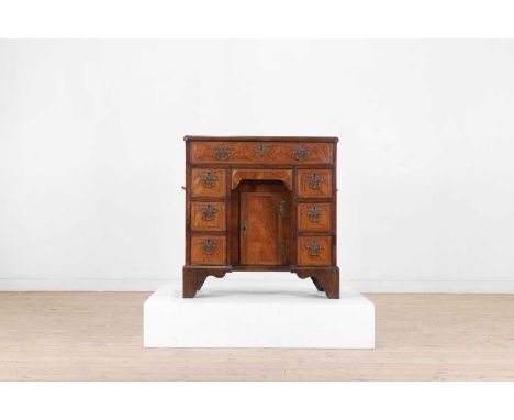 A George II walnut kneehole desk, mid-18th century and later, the quartered top above a single frieze drawer, with further dr