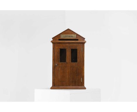 An oak letter box, 20th century, of architectural form with a single door,23cm wide14cm deep39cm high