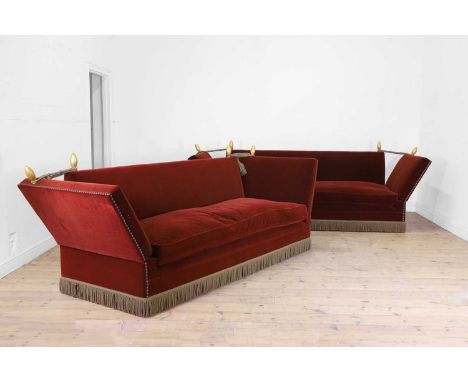 A pair of Knole sofas, 20th century, each upholstered in red velvet, with studded details and fringing, with giltwood finials