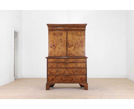 A George I walnut cabinet on chest, early 18th century and later, the upper section with a pair of doors enclosing a fitted i