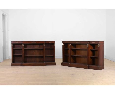 A pair of Regency-style mahogany open bookcases, 20th century, each of breakfront outline with foliate mounts, the shelves se