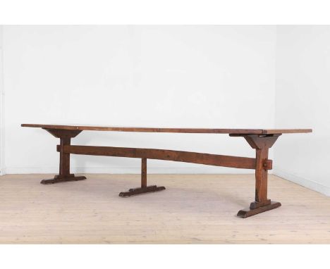 A long oak refectory table in the 17th-century style, 20th century, with a cleated plank top raised on three trestles united 