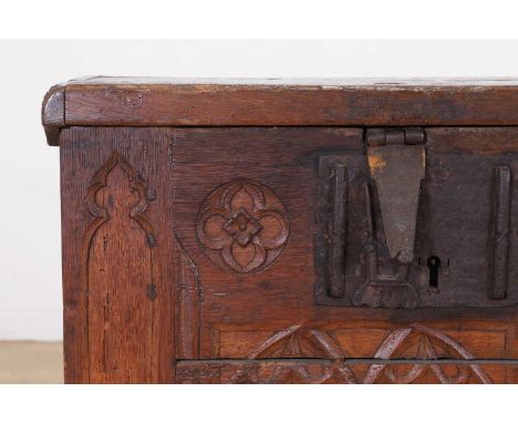 A Gothic oak coffer, 16th century, French, with a hinged lid and a tracery front panel, set with iron locks and handles, 126c