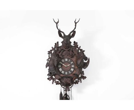 A Black Forest carved cuckoo clock, late 19th/early 20th century, richly embellished with game, foliage and a French horn, th