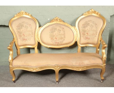 An Italian gilt wood conversation style sofa. Having embroided decoration to the back rests depicting classical scenes with l