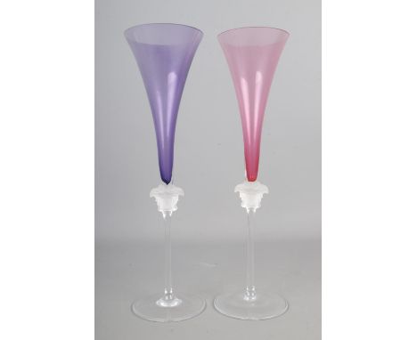 Two Rosenthal Versace Medusa head champagne glasses, with purple and pink flutes. Height: 30cm.