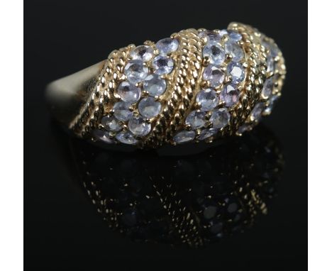 A 9ct Gold ring set with six rows of tanzanite stones, separated by a rope twist border. Size R½. Total weight: 4.1g