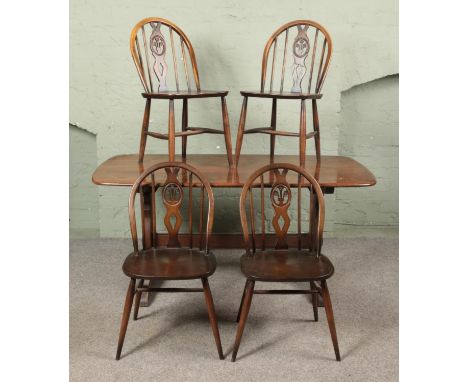An Ercol refectory style table along with four Ercol Fleur De Lis dining chairs.