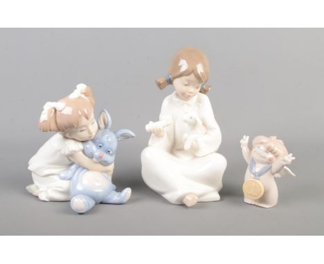 A collection of three Nao figures including girl with lamb and girl with bunny