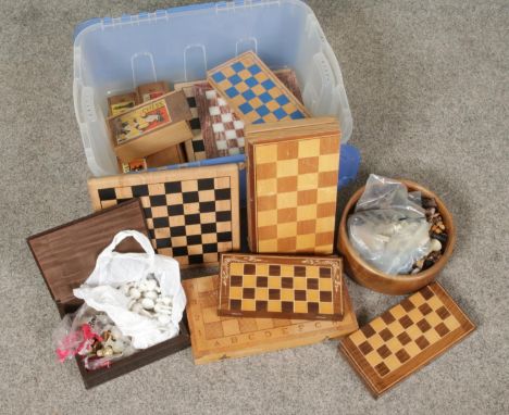 A box of mainly wooden chess boards. Includes draughts, and chess pieces, dominoes etc. Also includes marble chess examples.