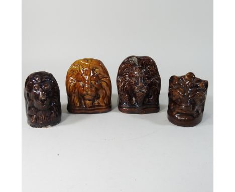Four various 19th century Staffordshire treacle glazed sash window stands, each decorated with a lion mask, highest 14cm