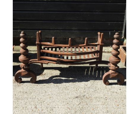 A large antique cast iron fire grate, of curved shape, 102cm wide overall