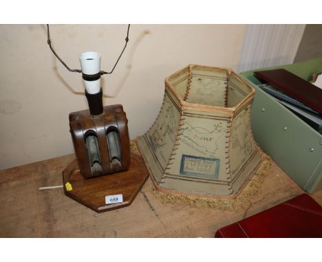 A vintage wooden lamp made from a pulley; and a shade printed with vintage maps 