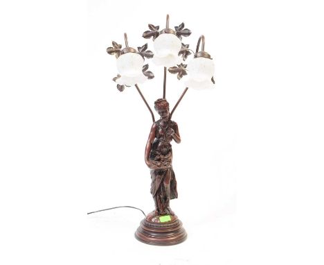 A 20th Century Art Nouveau style resin lamp light of female figure standing on circular stepped base with three arm lights de