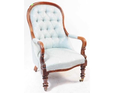 A 19th century Victorian mahogany buttonback armchair. The chair raised on turned legs to front, over castors. Featuring scro
