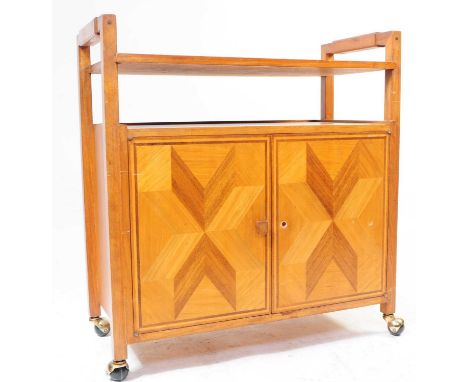 British Modern Design - A mid 20th century walnut veneer tea trolley. The trolley raised on squared supports over castors. Ha