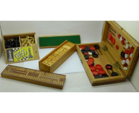 A collection of games including a chess set, cribbage board and dominoes 