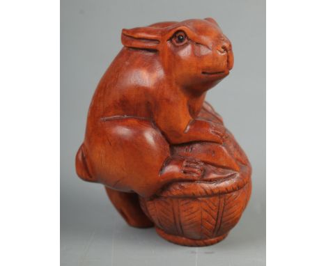 A Japanese carved Netsuke in the form of a rabbit on basket  