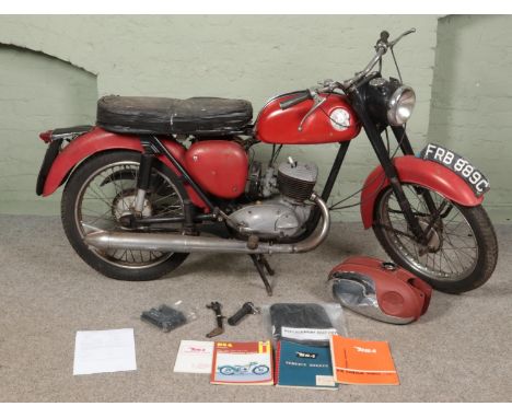 A BSA Bantam D10 motorbike and accessories. Includes additional fuel tank, replacement seat cover, handlebars, manual, docume