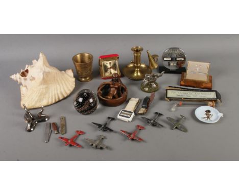 An assortment of collectables to include lead plane figures, conch shell, novelty ashtray, Caithness paperweight, etc.  