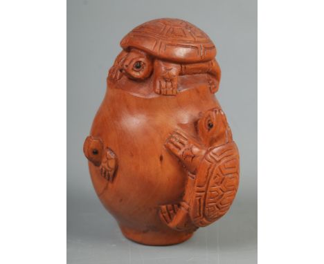 A Japanese carved Netsuke in the form of three tortoise on an egg  