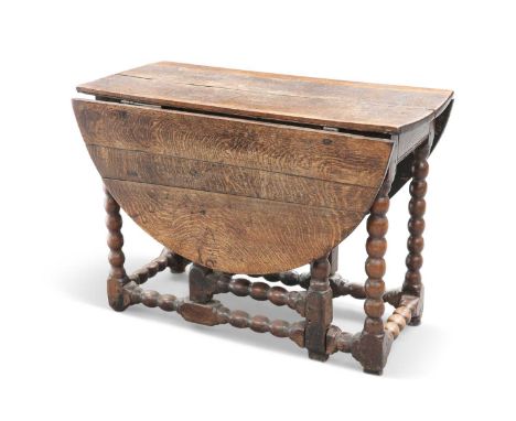 AN 18TH CENTURY OAK GATELEG TABLE AN 18TH CENTURY OAK GATELEG TABLE, with rounded leaves, bobbin-turned legs, and stretchers.