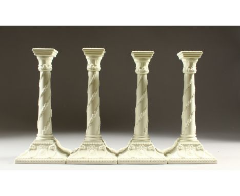 A SET OF FOUR WORCESTER STYLE BLANC DE CHINE GLAZED CANDLESTICKS, of classical design. 27cms high.