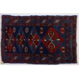 A GOOD SMALL PERSIAN RUG, dark blue ground, four motifs in a stylized border. 137cms x 94cms.